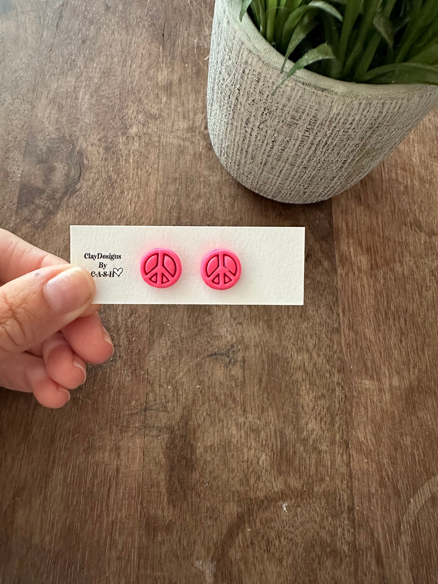 Pink peace sign studs